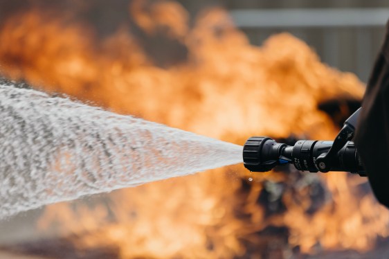 HEN Technologies nozzle spraying water with flames in background